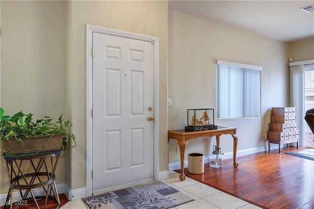 foyer entrance featuring light wood-style floors, visible vents, and baseboards