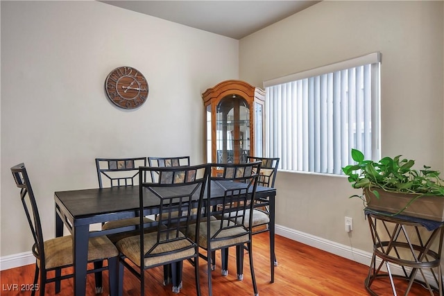 dining space with wood finished floors and baseboards