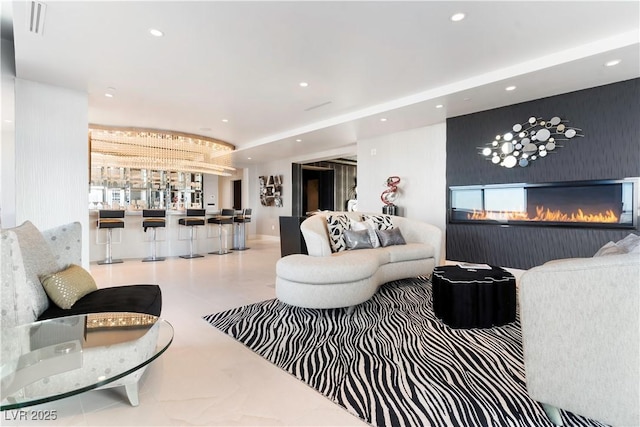 living area with recessed lighting and a glass covered fireplace