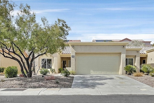 view of front facade featuring an attached garage, driveway, a tile roof, and stucco siding