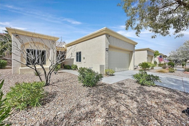 view of side of property with a garage, driveway, and stucco siding