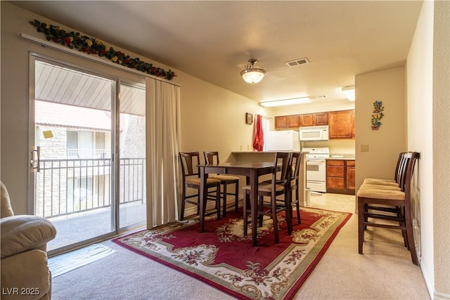 dining space with visible vents and light colored carpet