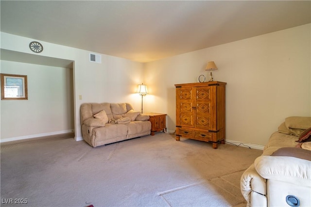 living area featuring visible vents, light carpet, and baseboards