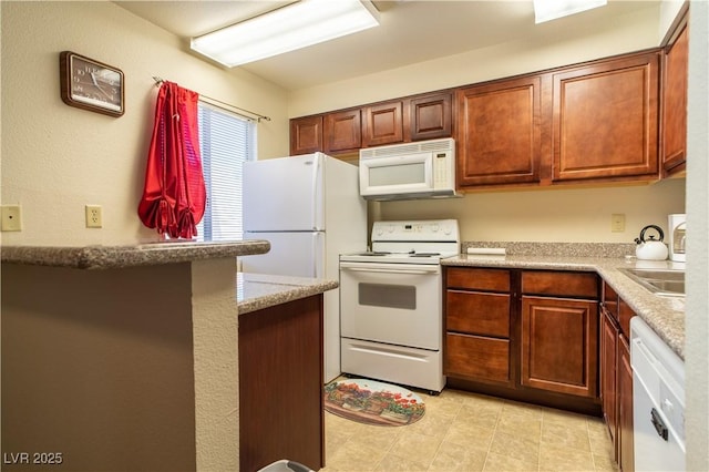 kitchen featuring white appliances and brown cabinetry