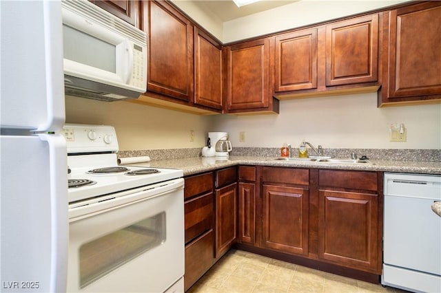 kitchen with white appliances, light countertops, and a sink