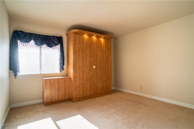 empty room with baseboards and carpet flooring