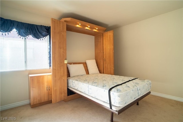 bedroom with baseboards and light colored carpet