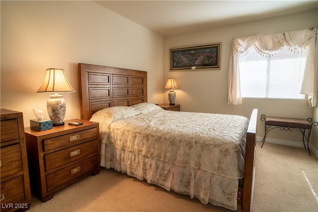 bedroom with baseboards and light colored carpet