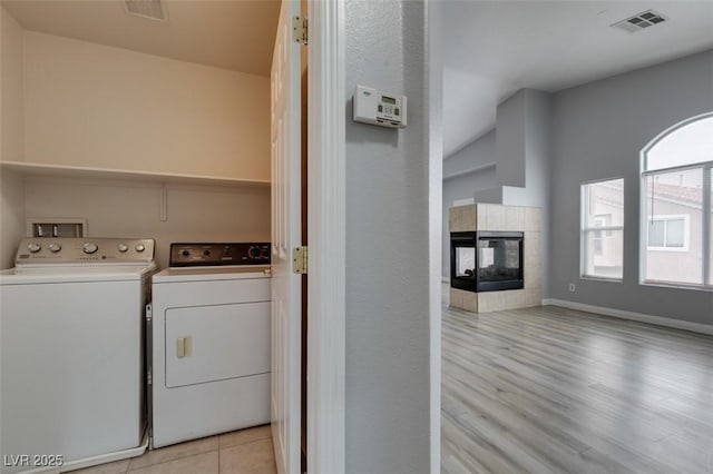 laundry area featuring laundry area, visible vents, separate washer and dryer, and a tile fireplace