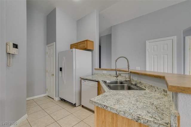 kitchen with light tile patterned floors, light countertops, a sink, white appliances, and a peninsula