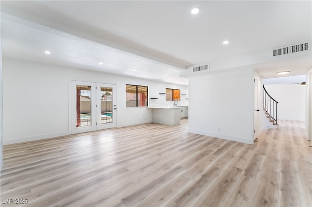 unfurnished living room featuring light wood-style floors, recessed lighting, visible vents, and stairs