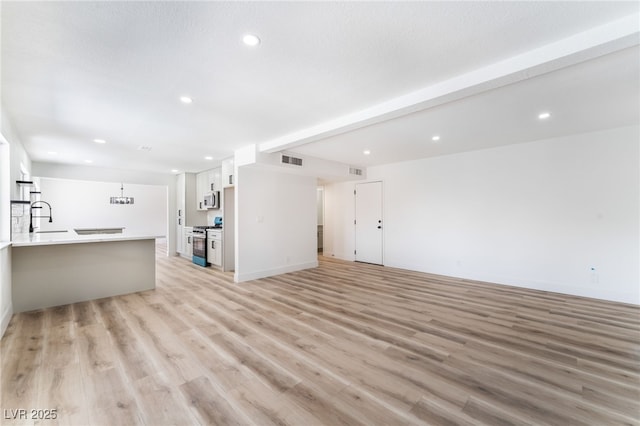 unfurnished living room with light wood-style floors, visible vents, and recessed lighting