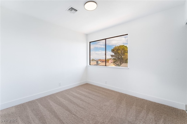 empty room with carpet, visible vents, and baseboards