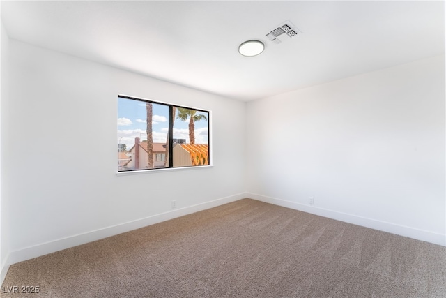 carpeted spare room with visible vents and baseboards