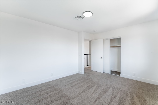 unfurnished bedroom with baseboards, carpet, visible vents, and a closet