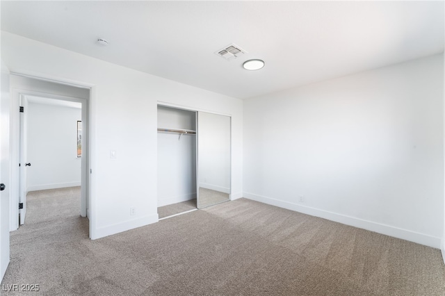 unfurnished bedroom featuring carpet floors, a closet, visible vents, and baseboards