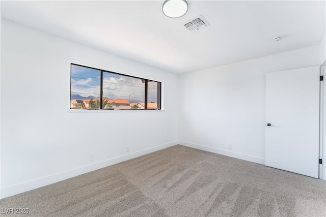 carpeted spare room with baseboards and visible vents