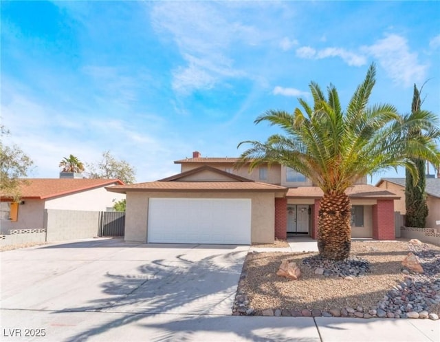 ranch-style house featuring a garage, driveway, fence, and stucco siding