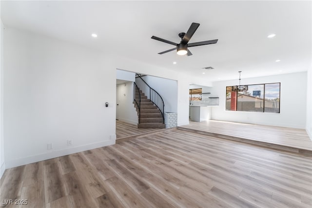 unfurnished living room with stairway, wood finished floors, visible vents, and recessed lighting