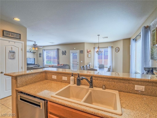 kitchen with open floor plan, a healthy amount of sunlight, dishwasher, and a sink