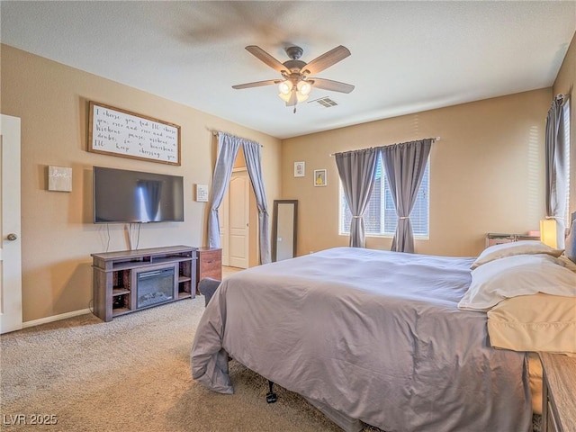 carpeted bedroom featuring baseboards, visible vents, and a ceiling fan