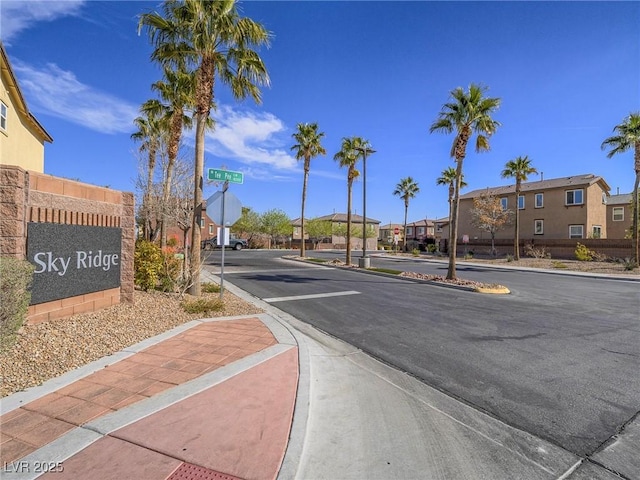 view of road with sidewalks, traffic signs, a residential view, and curbs