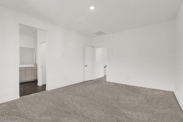 unfurnished bedroom featuring baseboards, visible vents, connected bathroom, carpet floors, and recessed lighting