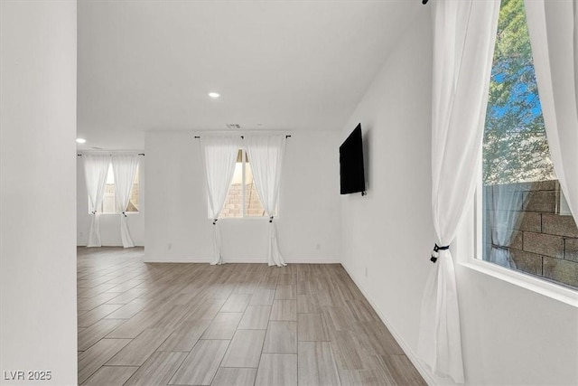 unfurnished living room with baseboards, wood finished floors, and recessed lighting