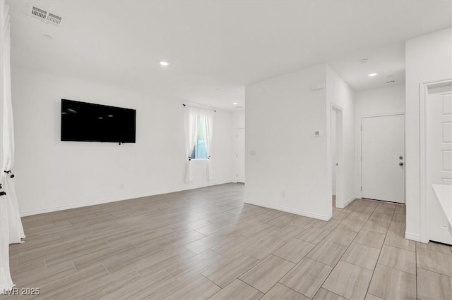 unfurnished living room with light wood-type flooring, visible vents, baseboards, and recessed lighting