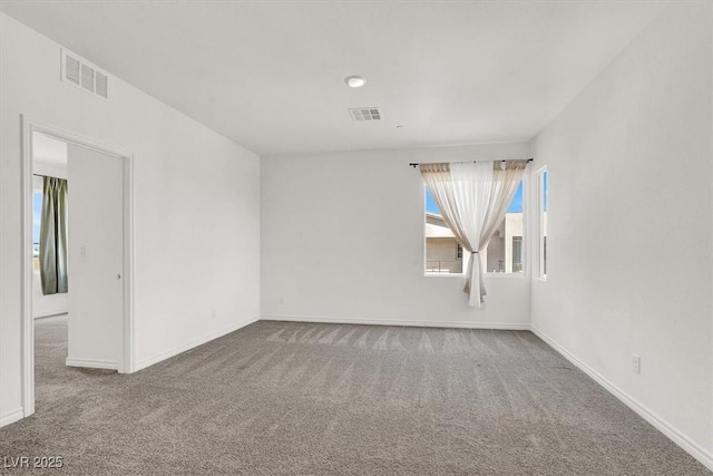 spare room featuring carpet floors, baseboards, and visible vents