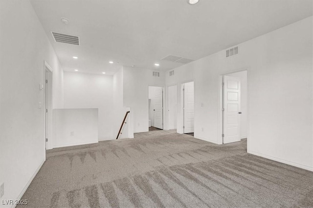 carpeted empty room with baseboards, visible vents, and recessed lighting