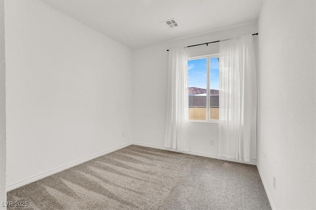 unfurnished room with carpet floors, visible vents, and baseboards