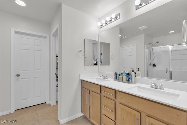 bathroom with double vanity, a stall shower, a sink, and tile patterned floors