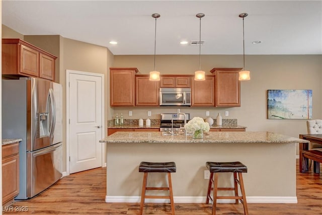 kitchen featuring a sink, stainless steel appliances, light wood-style floors, and visible vents