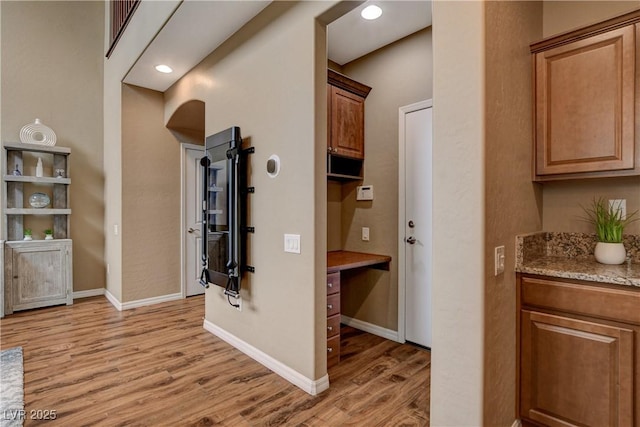 hall with recessed lighting, baseboards, and light wood finished floors