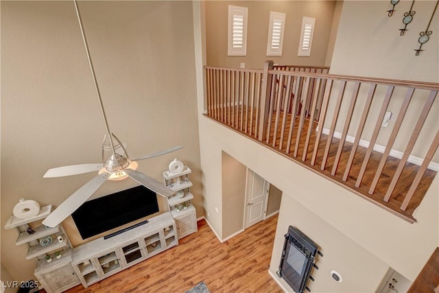 living room featuring baseboards, wood finished floors, and a ceiling fan