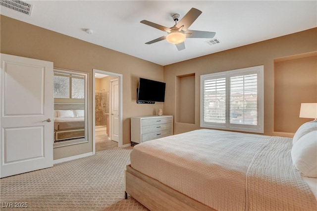 bedroom featuring visible vents, light colored carpet, connected bathroom, and baseboards