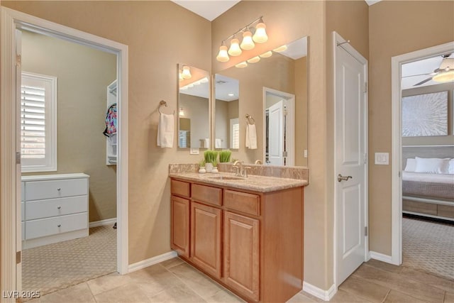 bathroom featuring baseboards, a ceiling fan, ensuite bath, and vanity