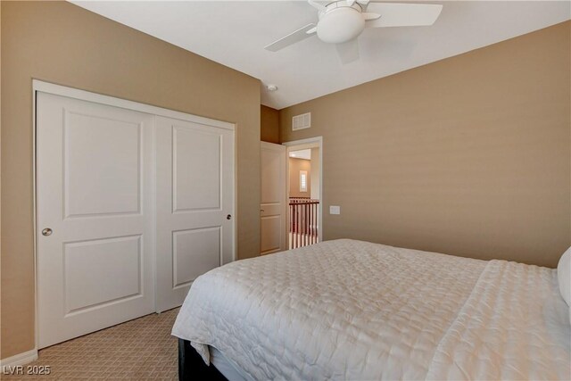 bedroom featuring a closet, visible vents, light colored carpet, and a ceiling fan