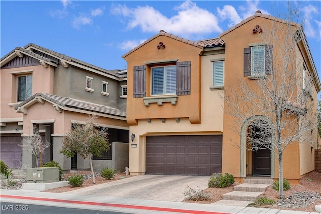 view of front of property featuring a tiled roof, stucco siding, driveway, and an attached garage