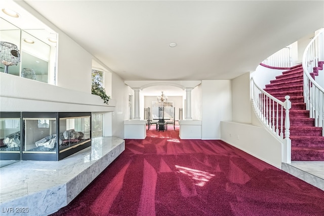 corridor with stairway, carpet, and ornate columns