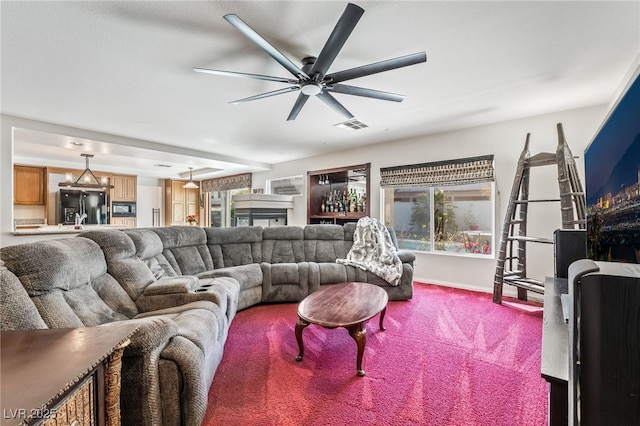 living area featuring carpet, a ceiling fan, visible vents, and baseboards