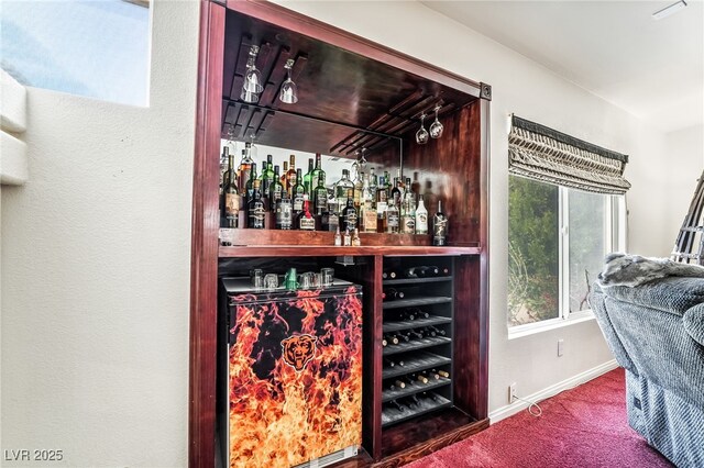 bar featuring a dry bar, baseboards, and carpet floors