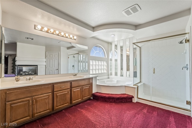 full bathroom featuring a garden tub, a stall shower, visible vents, and a sink