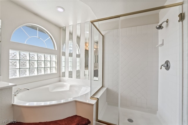 bathroom featuring a bath, plenty of natural light, and a shower stall