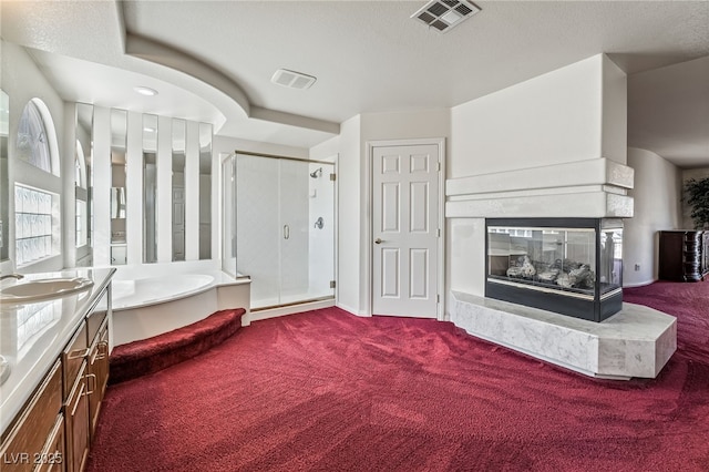 bathroom with a garden tub, visible vents, a multi sided fireplace, and a stall shower