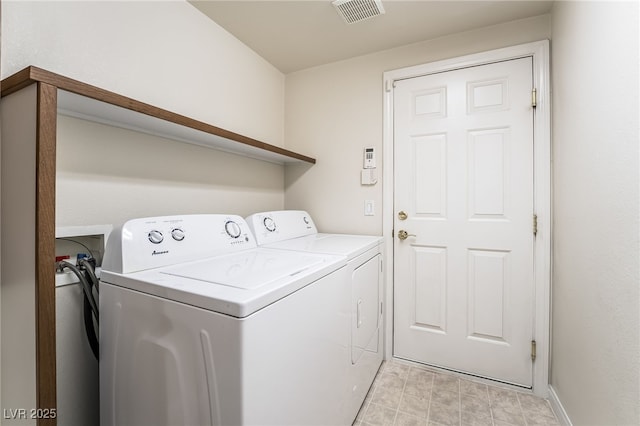 clothes washing area featuring visible vents, laundry area, and separate washer and dryer