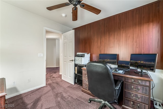 carpeted home office with baseboards and ceiling fan
