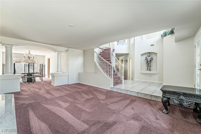 interior space featuring carpet, visible vents, ornate columns, and stairway