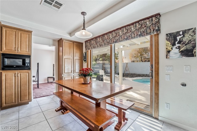 dining area featuring baseboards, visible vents, light tile patterned floors, and a tray ceiling